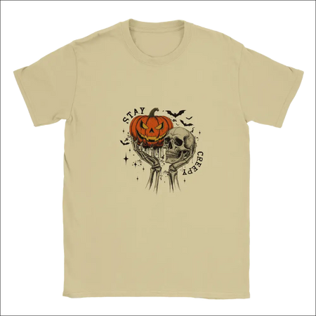 Beige Stay Creepy unisex t-shirt with skeletal hands, glowing orange pumpkin, skull, and arched text