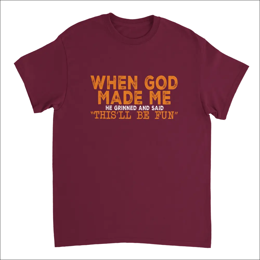 Maroon short-sleeved t-shirt with orange distressed text: when god made me he grinned and said thisll be fun. Heavyweight cotton classic fit
